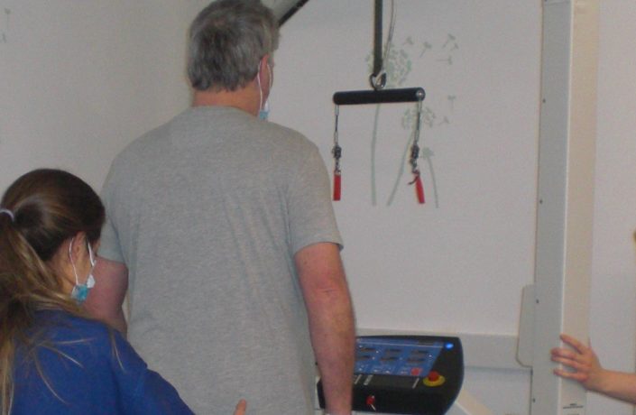 Patient using Stroke Rehabilitation treadmill with support from Physio team